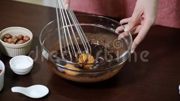 女性用手在透明的碗里用搅拌器揉生面团视频的预览图
