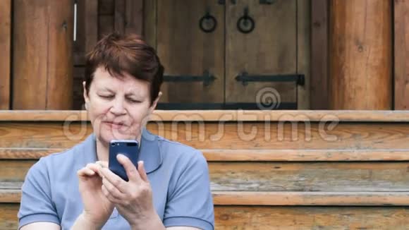 老年妇女在户外浏览手机视频的预览图