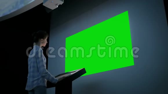 女人看空白大互动墙展示绿色屏幕概念视频的预览图