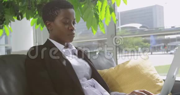 女商人坐在沙发上办公室里用笔记本电脑视频的预览图