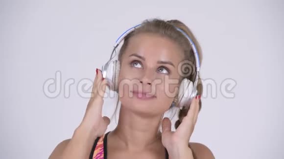 快乐的年轻美丽的金发女人听音乐视频的预览图