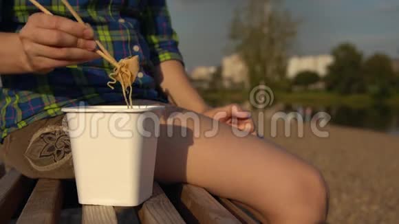 女孩在鹅卵石滩吃热面条视频的预览图