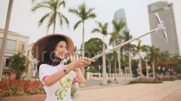 穿着国装的女孩在摩天大楼的背景下在岘港市中心自拍视频的预览图