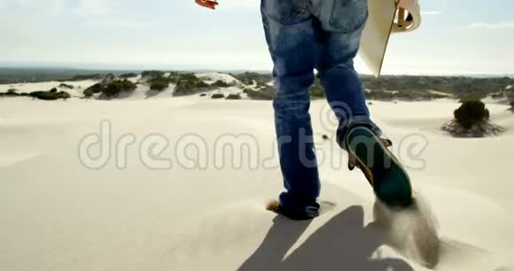 在沙漠中用沙板行走的人视频的预览图
