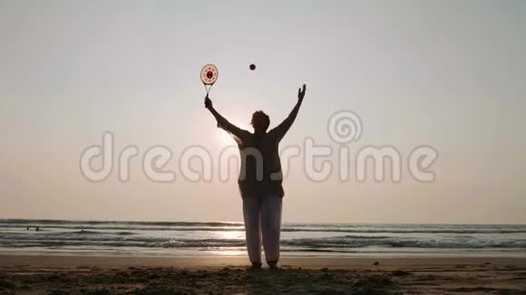日落时分一位资深女士在海滩上练习太极气球视频的预览图