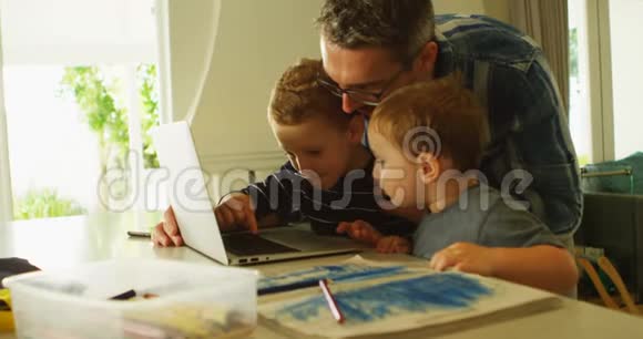 4k客厅的父亲和兄弟姐妹使用笔记本电脑视频的预览图