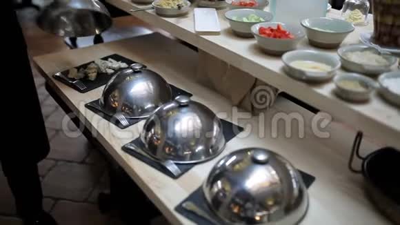 餐厅的自助餐把切好的奶酪和香肠放在盘子里视频的预览图