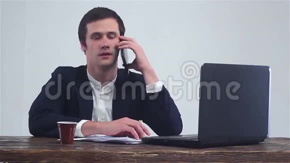 年轻的商人在打电话在笔记本电脑上工作视频的预览图