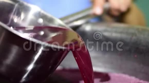 Bignay家居酒加工果汁用不锈钢舀入检查稠度视频的预览图