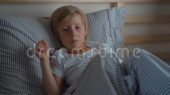 在床上生病的小男孩一个男孩在床上咳嗽时的超慢镜头婴儿流感概念视频的预览图