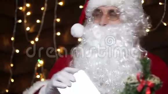 特写圣诞老人送礼物给精灵精灵把礼物放在圣诞树下视频的预览图