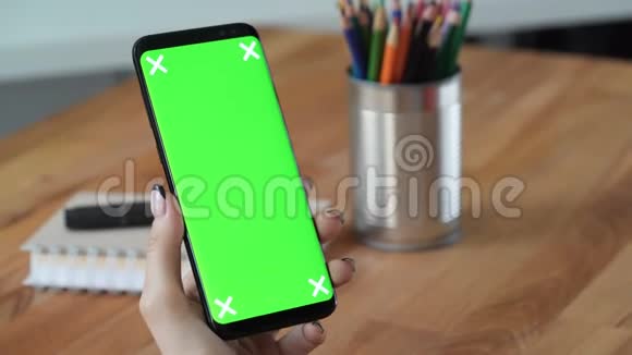 手持绿色屏幕显示手机的人视频的预览图