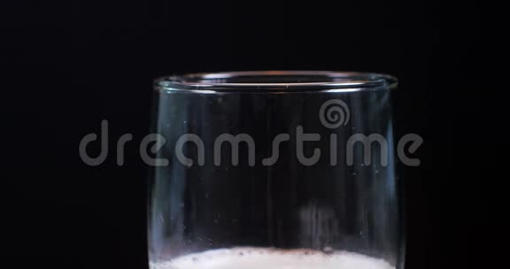 把啤酒倒在一杯啤酒上杯头泡沫溢出黑底视频的预览图
