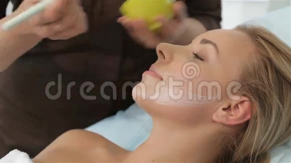 女性美容师在病人脸上涂化妆品视频的预览图