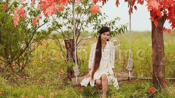 亚洲美丽的越南女孩长发在秋季花园的秋千上越南视频的预览图