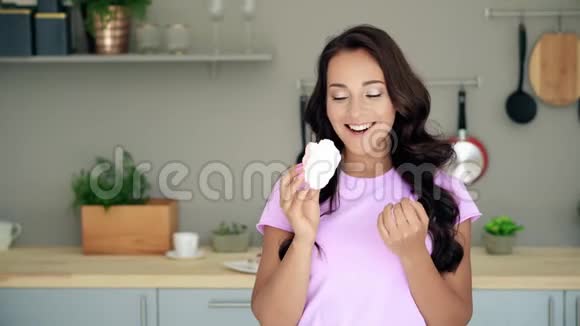 年轻女人在厨房里吃甜蛋糕视频的预览图