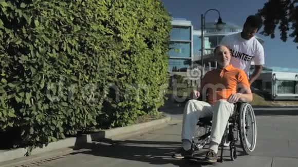 积极的印度教志愿者推着一个轮椅的人视频的预览图