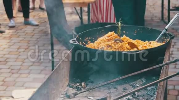 乌孜别克皮拉夫在街火烧过的大锅里煮饭视频的预览图