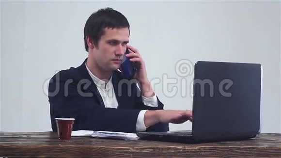 年轻的商人在打电话在笔记本电脑上工作视频的预览图