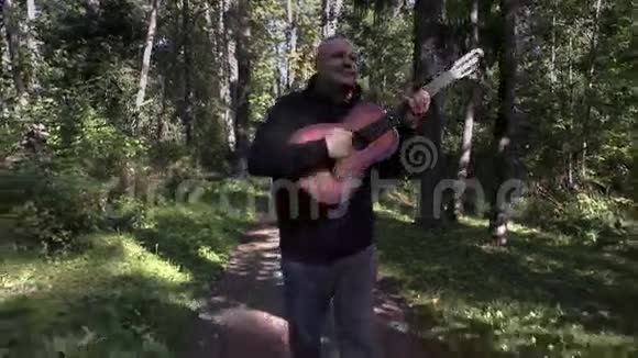 快乐的人弹吉他在公园散步视频的预览图