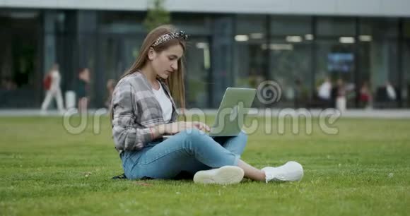 学生坐在公园里用笔记本电脑工作视频的预览图