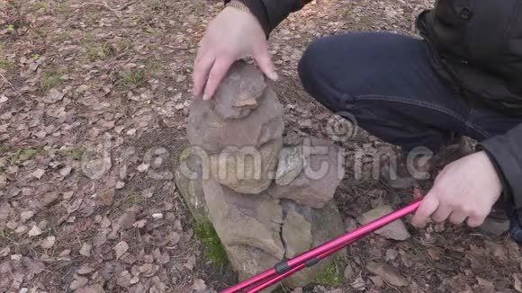 带着登山杖的人把石头放在身边视频的预览图