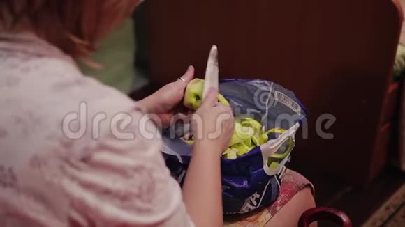 用刀子清洗苹果的女孩的手从后面看视频的预览图