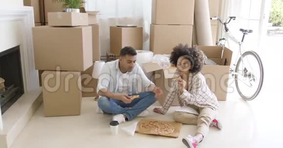 饥饿的年轻夫妇在地板上吃披萨视频的预览图