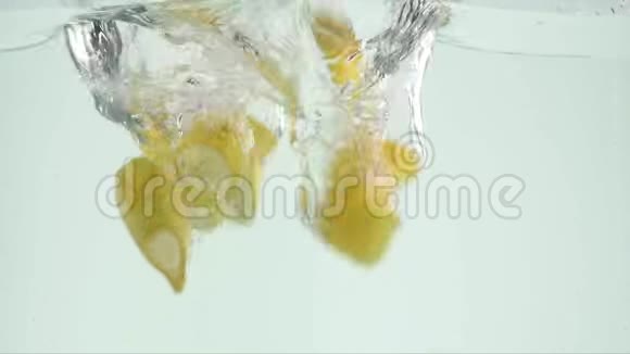 香蕉掉进水里香蕉碎片滴在白色背景下的水里新鲜的黄色香蕉水果跳水视频的预览图