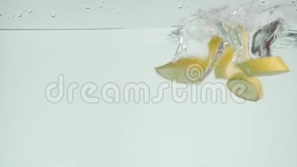 香蕉掉进水里香蕉碎片滴在白色背景下的水里新鲜的黄色香蕉水果跳水视频的预览图