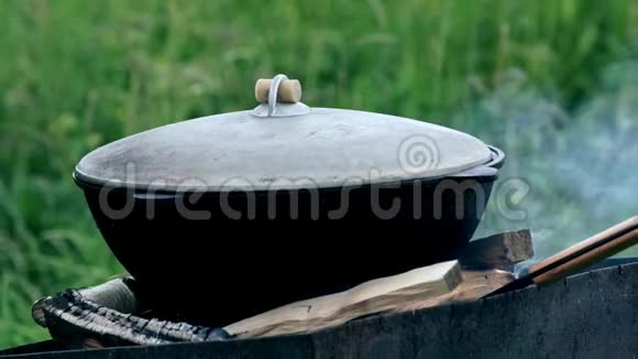 在大锅里准备食物在远足时生火做饭视频的预览图