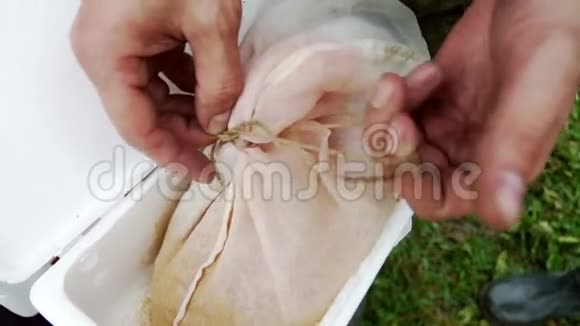 渔夫双手解开袋子里的虫子钓鱼虫钓鱼饵视频的预览图