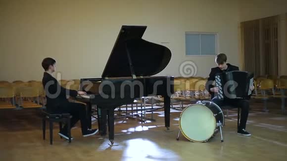钢琴演奏家和手风琴演奏家在空房演奏音乐视频的预览图