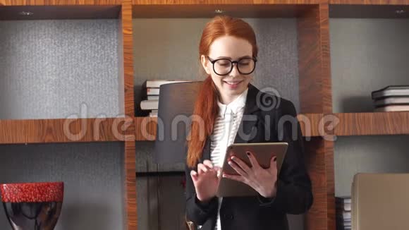 年轻成功的女商人在家庭客厅家庭办公室使用平板电脑视频的预览图