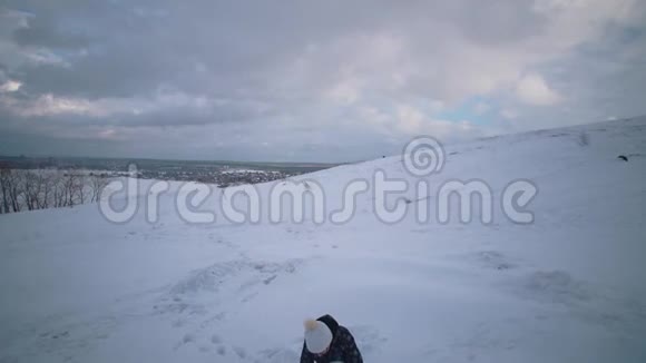 妇女和儿童一起在山上雕刻一个雪人视频的预览图