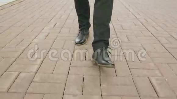 Steadicam拍摄的特写镜头商人穿着鞋子走在街边的人行道上视频的预览图