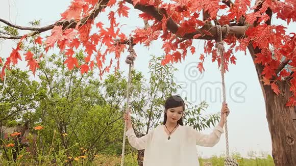 亚洲美丽的越南女孩长发在秋季花园的秋千上视频的预览图