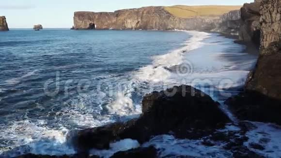 波浪跑到海滩上白色泡沫从黑色海滩的背景上的波浪海洋冲浪视频的预览图