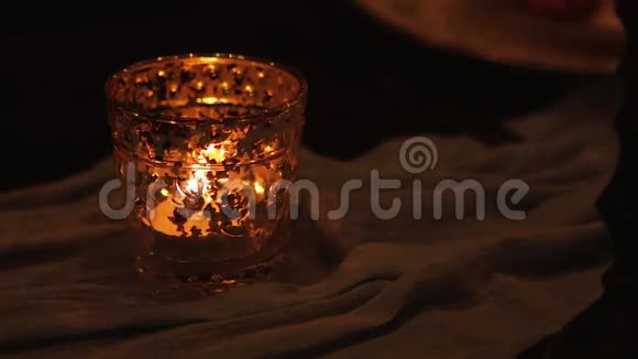 在桌上的烛台上用布把烛台上的蜡烛合上视频的预览图