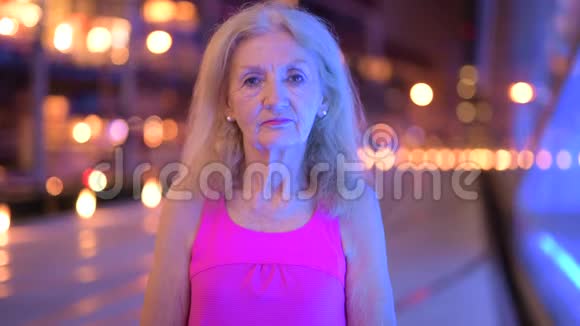 年长妇女夜间微笑户外活动的肖像视频的预览图