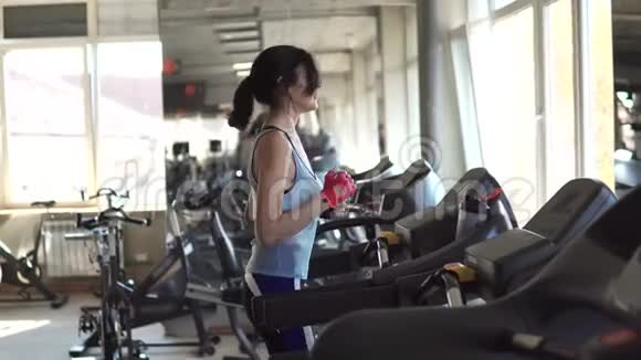漂亮的年轻女子在健身房运动跑步机上的女孩视频的预览图