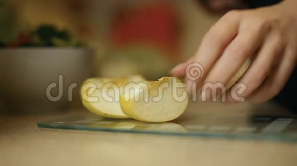 女青年在厨房的玻璃板上切苹果视频的预览图