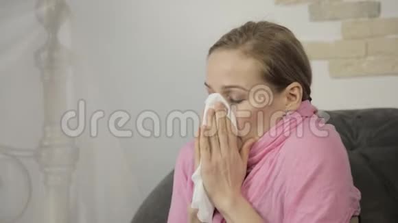 生病的女人用餐巾纸擦鼻子大声打喷嚏视频的预览图