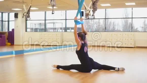 慢动作女孩站着用绳子吊床做瑜伽视频的预览图