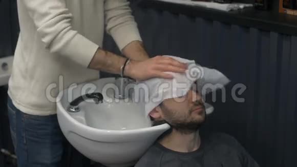 理发师男子剪头前洗头视频的预览图