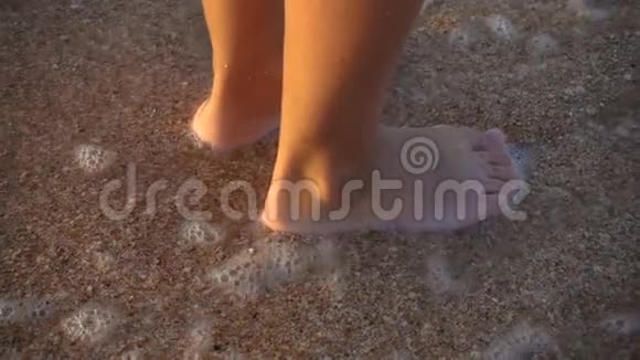 用流动的水立在海浪前的儿童腿特写视频的预览图