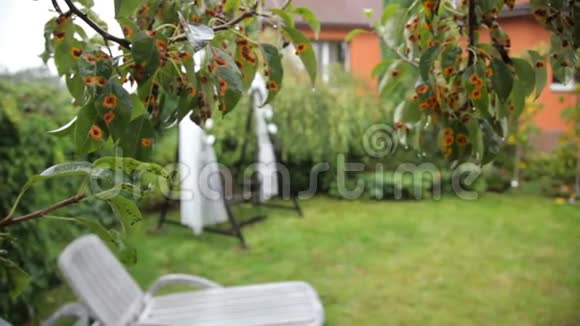 在房子的院子里为婚礼装饰的秋千婚礼在雨中摇摆视频的预览图