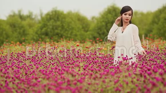 一个长着黑色长发的越南女孩站在一片紫色的花丛里视频的预览图