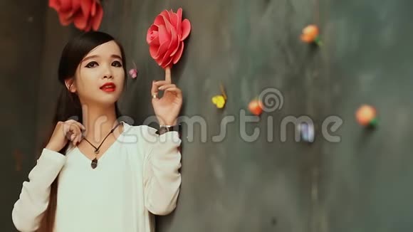 越南一位黑发少女长发戴着人造玫瑰靠墙摆姿势河内视频的预览图