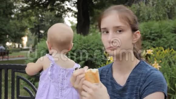 一个年轻的保姆挑了一块面包放进嘴里一个女婴直视着镜框视频的预览图